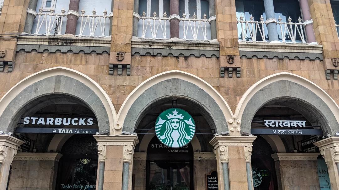 Starbucks storefront with Tata Alliance signage on a heritage building in India
